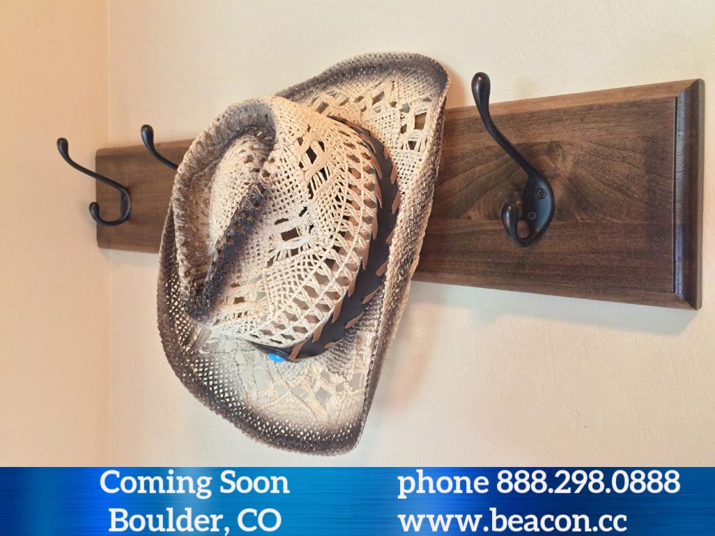 Two crocheted straw hats on wooden hooks