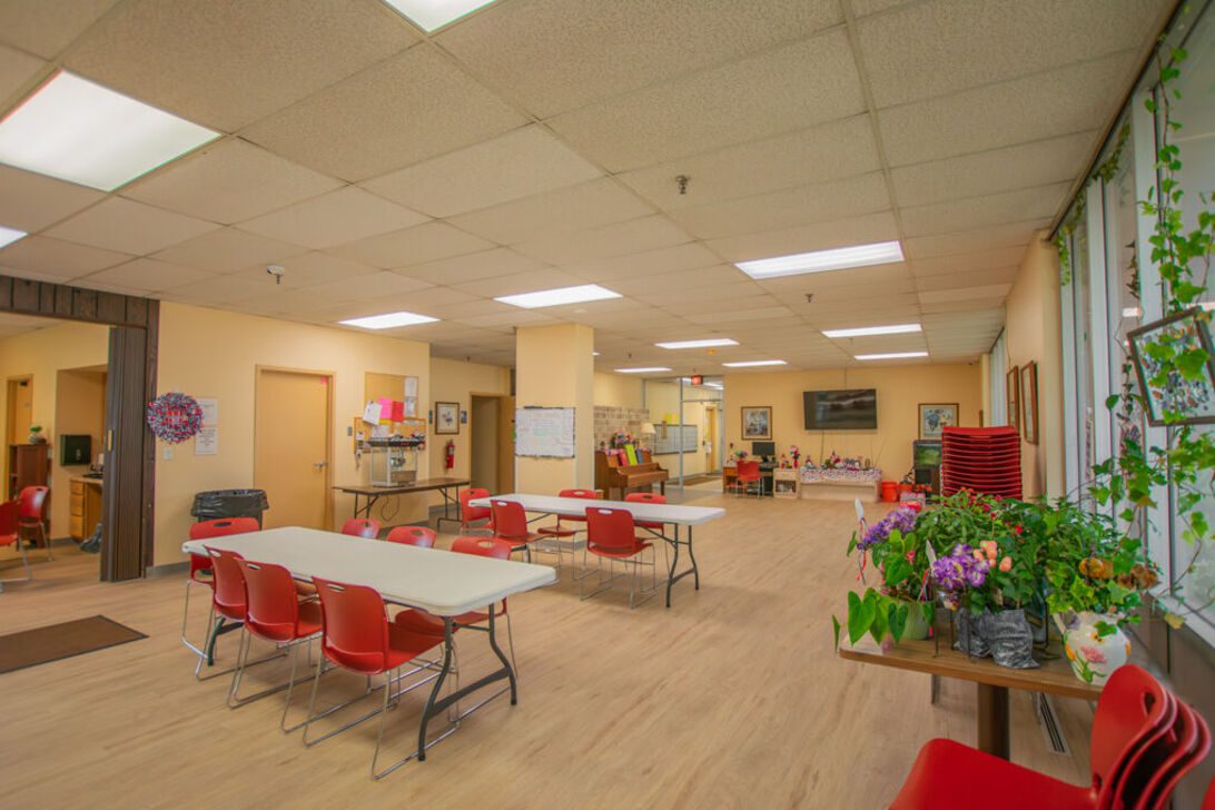 Community room with tables and red chairs