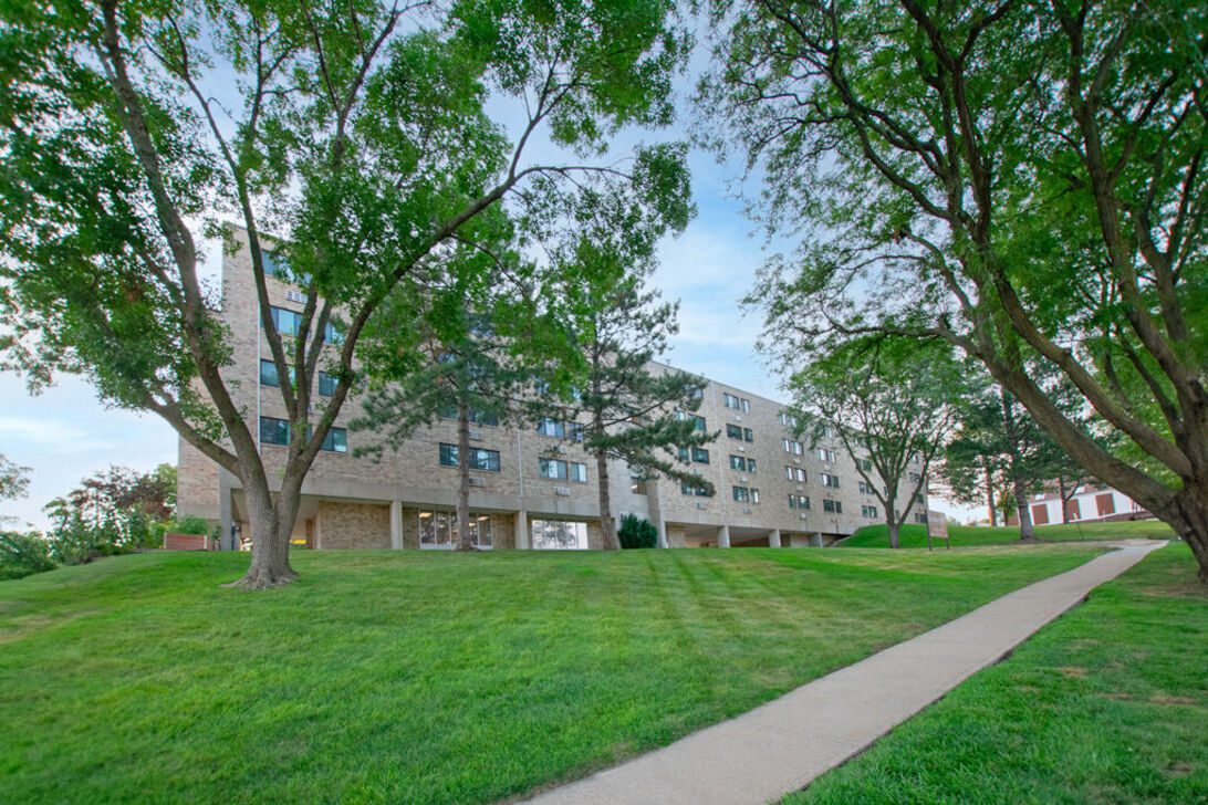 Brick apartment building with lawn and sidewalk