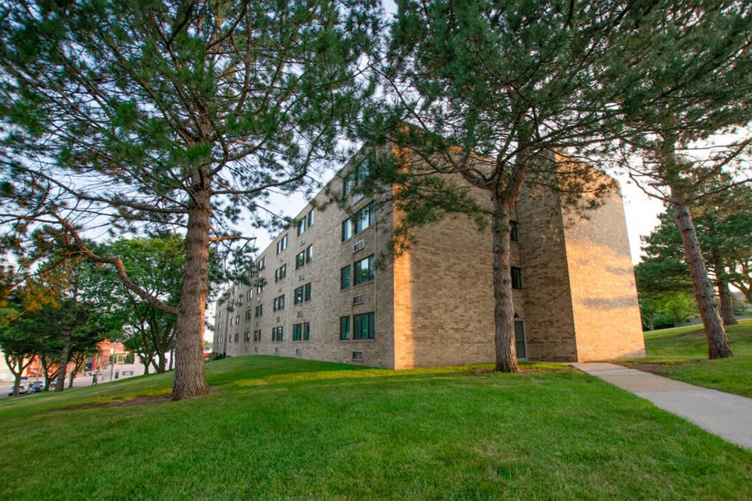 Brick apartment building with trees and lawn
