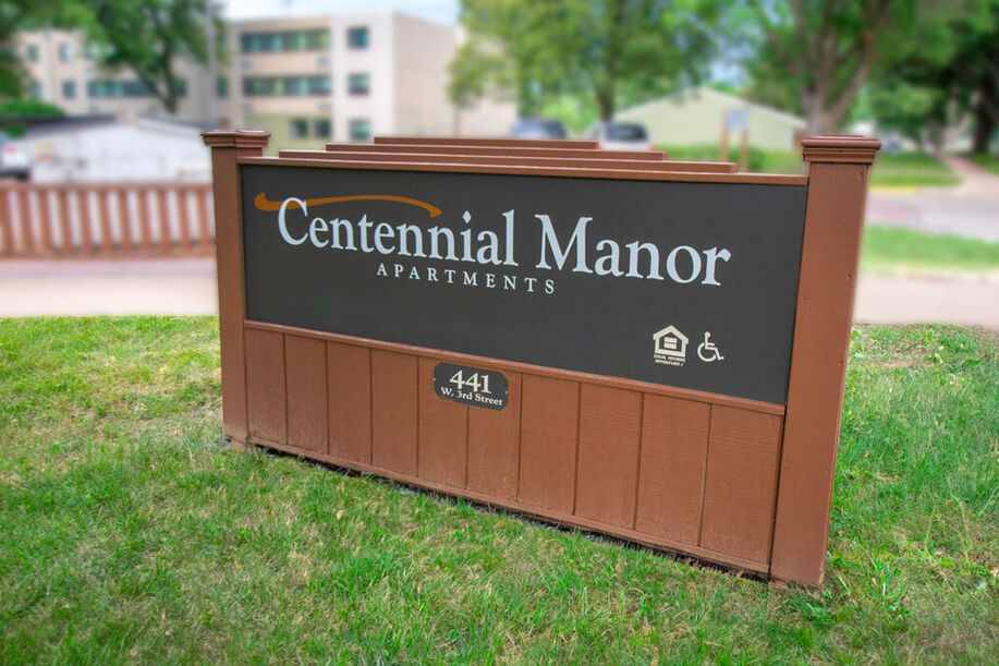 Centennial Manor Apartments sign on grass