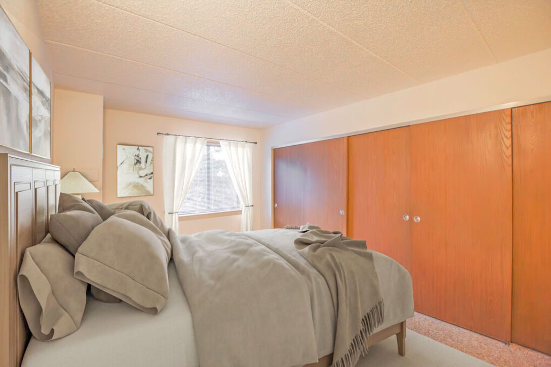 Cozy bedroom with bed and wooden closets