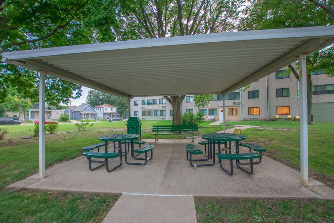 Sheltered picnic area with green tables